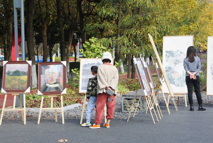 家长带着孩子一同看展。