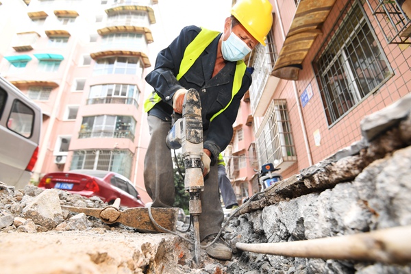 11月10日，施工工人正在贵阳市南明区大理石路片区老旧小区改造项目中使用电镐破除旧地面。