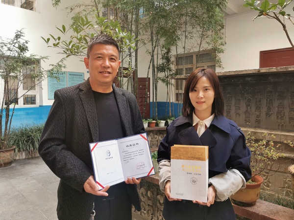 大方县图书馆馆长黎立（右）向陈福来（左）颁发作品收藏证书。