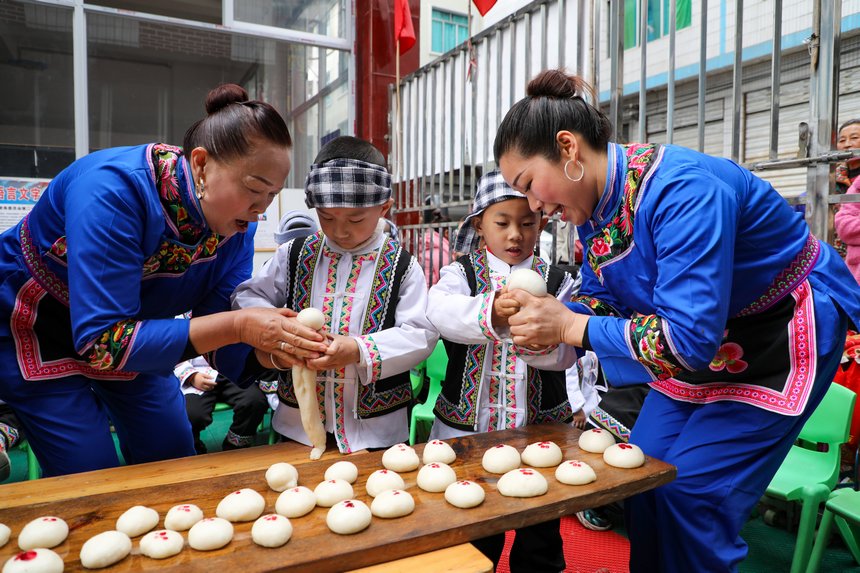 幼儿园小朋友们在学捏糍粑。