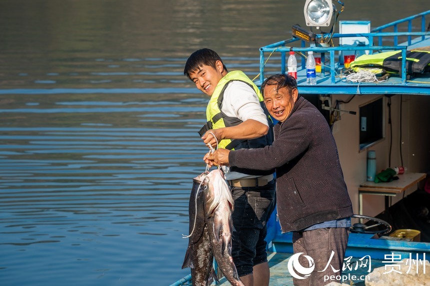 工作人员展示收获的鳙鱼。人民网记者 涂敏摄