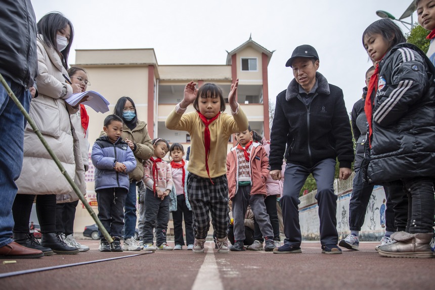 2022年12月15日，贵州省黔东南州施秉县甘溪乡中心小学的学生在冬季校运会上参加立定跳远比赛。