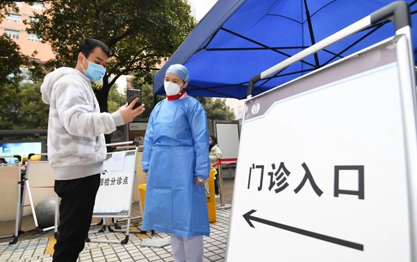图片医务人员正在查验来院就诊人员的48小时核酸检测证明