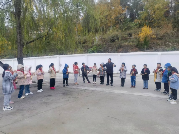石阡县国荣乡联合小学的留守儿童在李逢跃的指导下正在练习打快板。谭文斌摄
