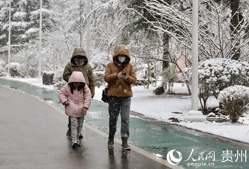 市民在觀山湖公園內迎雪前行。人民網 顧蘭雲攝