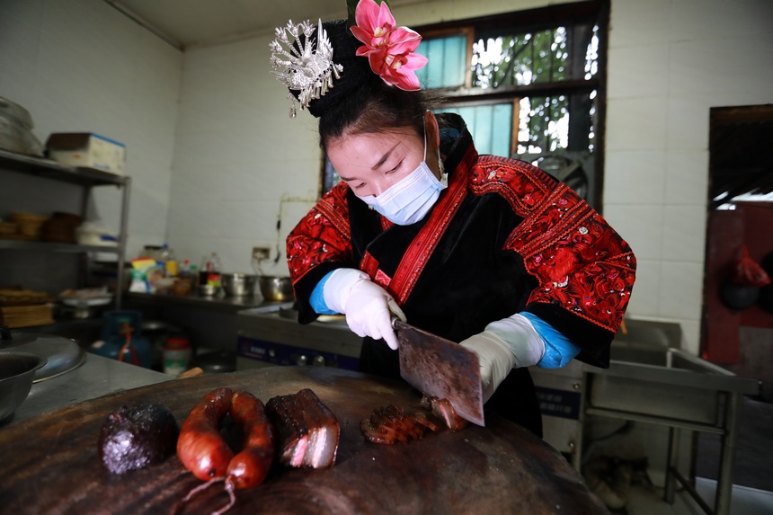 2013年1月2日，苗族群众在切成品的腊肉。