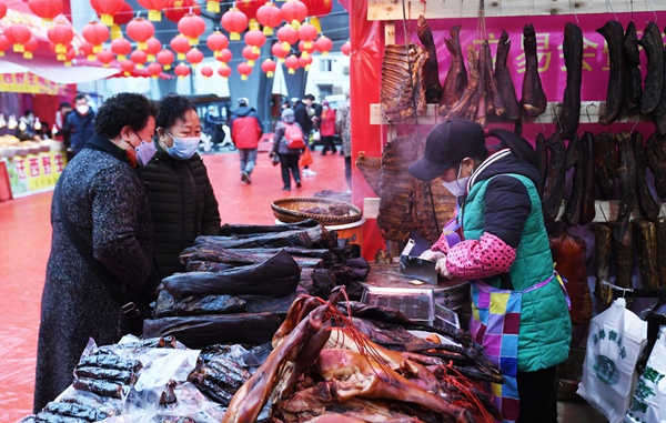 12月31日，市民在南明区2023幸福中国-贵阳第八届迎春年货节集市选购腊味食品。