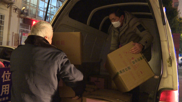普定县卫生健康局工作人员搬运“防疫健康包”物资。