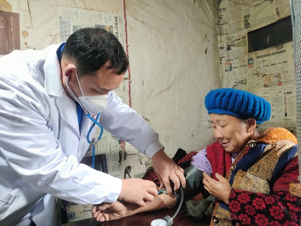 桐梓县马鬃苗族乡卫生院执业助理医师、院长 胡鹏飞正在给陈顺珍检查。