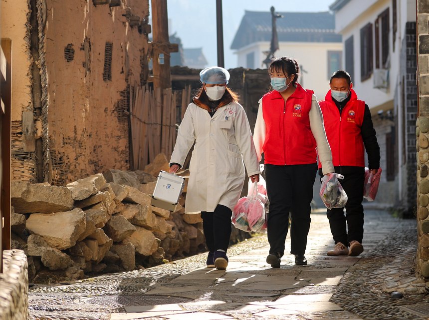 2023年1月8日，在贵州省黔东南州岑巩县水尾镇马家寨村，村医和党员志愿者为老年人送防疫健康包。