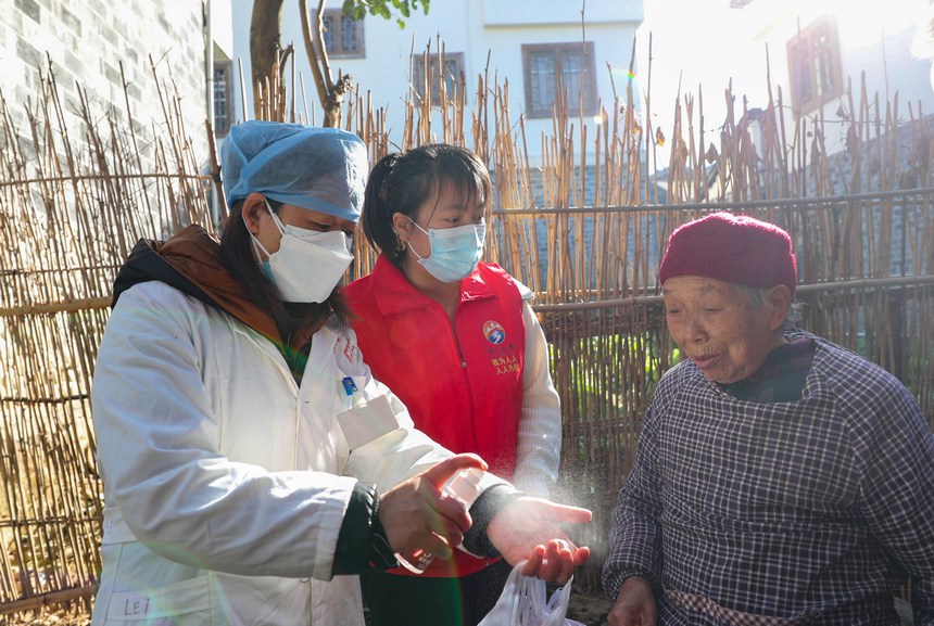 2023年1月8日，在贵州省黔东南州岑巩县水尾镇马家寨村，村医和党员志愿者向老年人介绍防疫健康包内酒精的使用方法。