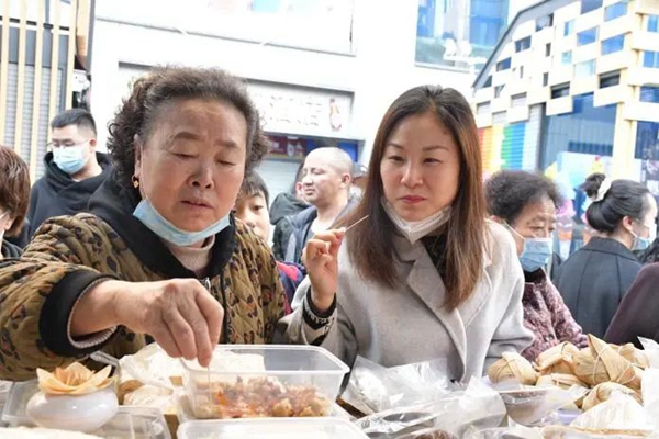 图片1月10日，青云路步行街“年货大街”上市民正在试吃年货7