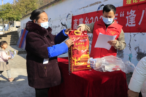 图4：乡文化中心文化副主任姜骄炜正在给志愿发放生活用品
