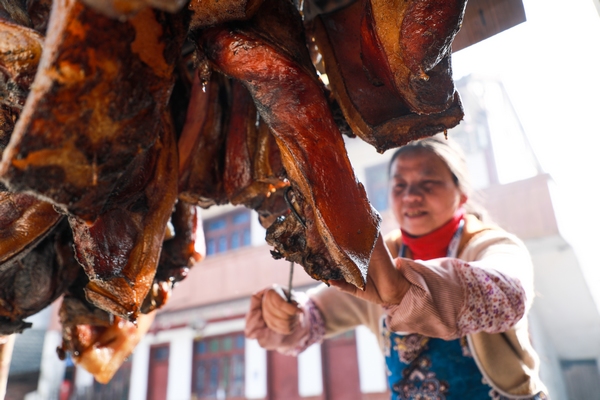 1月15日，贵州省大方县八堡乡的新开村村民李明珍在熏腊肉。周训贵摄