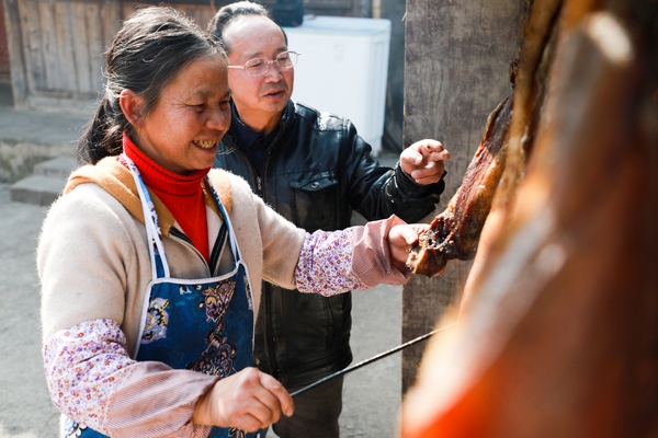 1月15日，貴州省大方縣八堡鄉的新開村村民楊國明、李明珍夫婦在熏臘肉。周訓貴攝