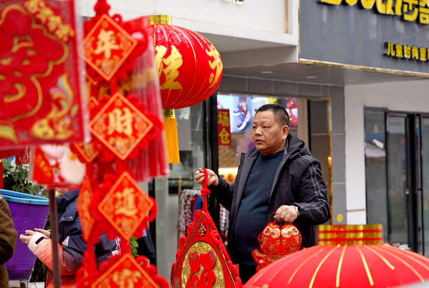 2023年1月18日，贵州省纳雍县城，市民购买中国结和灯笼。