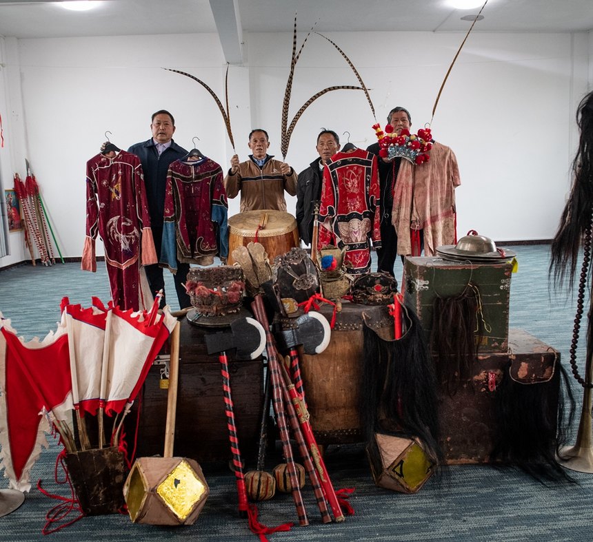 汉寨侗戏班的演员在展示老物件。