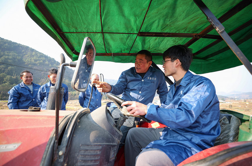 1月31日，老师（车内左）给乡镇农机手讲解农机的驾驶技巧。