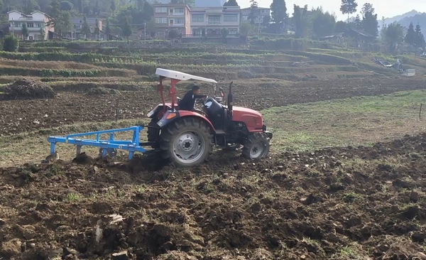 习水县良村镇吼滩坝区翻地机正在地里翻犁土地。