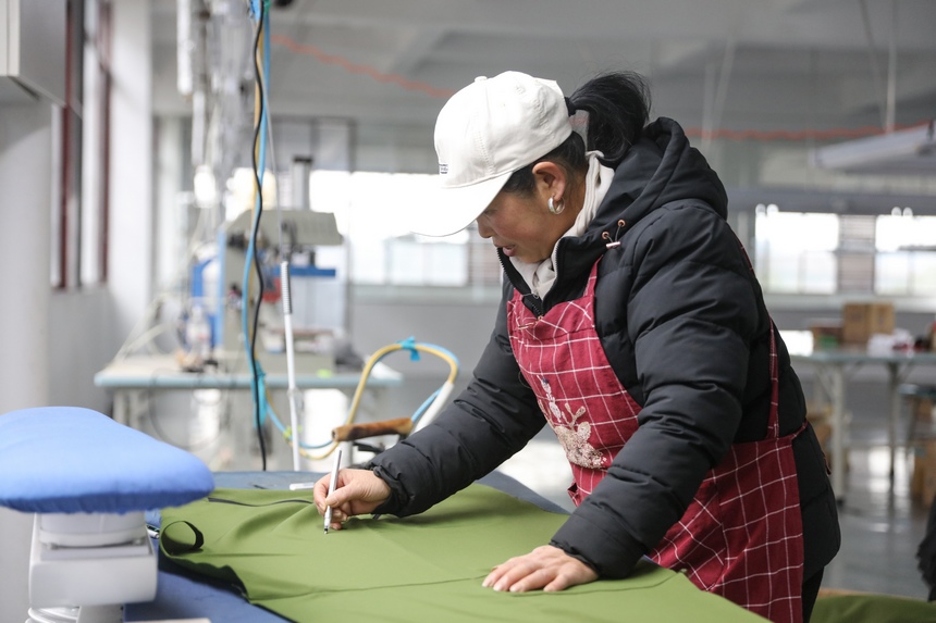 2023年2月13日，贵州省施秉县工业园区内 贵州丛卉服饰有限公司工人在赶制出口订单。