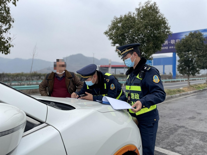 交通執法人員對過往客運車輛進行登記。