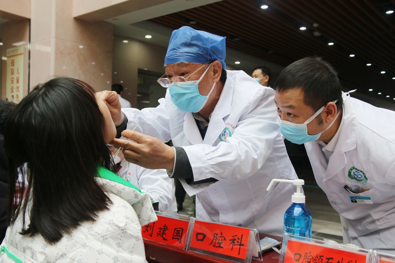 遵义医科大学校长刘建国为前来问诊的患者检查口腔。任丹摄