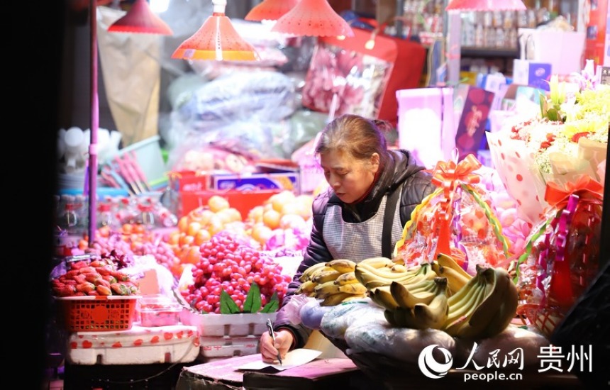 夜市水果摊上的老板在认真记录。人民网 顾兰云摄