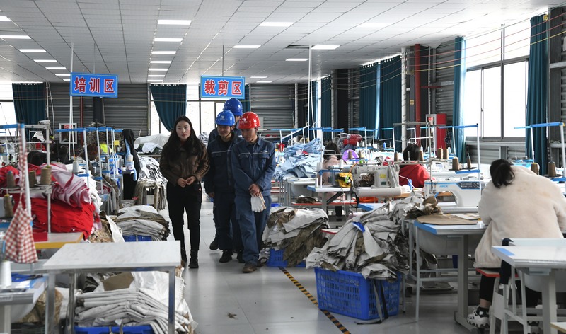 晴隆县龙发服饰有限责任公司负责人介绍车间生产情况。