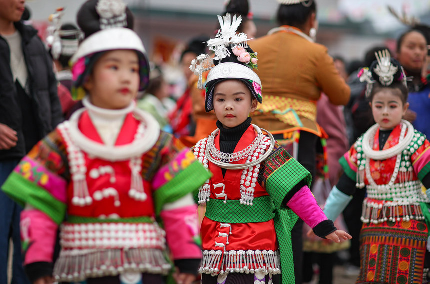 2月19日，身著節日盛裝的苗族小女孩在“望會節”上跳傳統蘆笙舞。