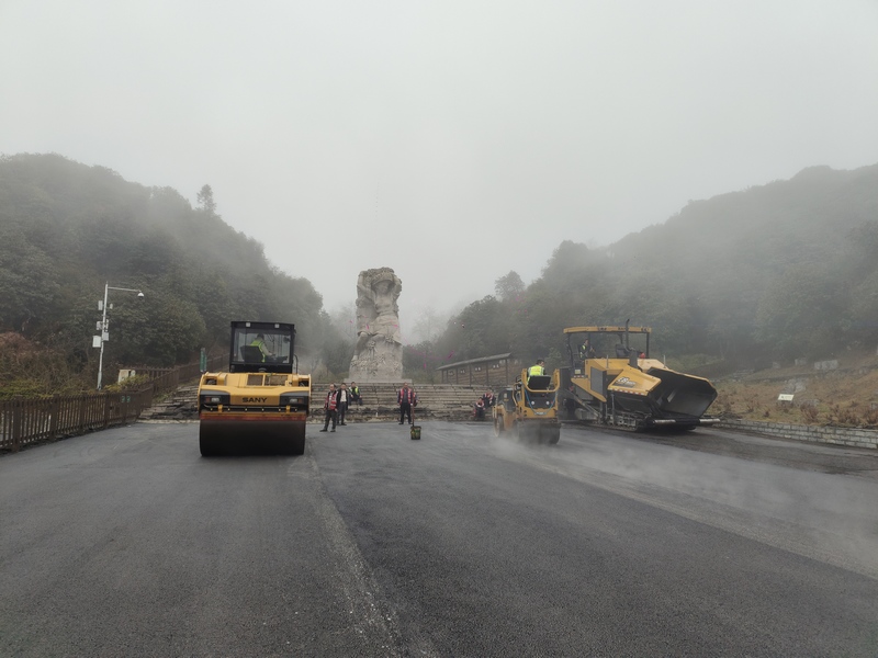 攤鋪機、壓路機正在給道路鋪瀝青。