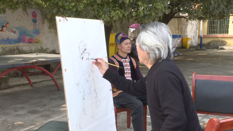 安顺市艺术家为当地村民作画。