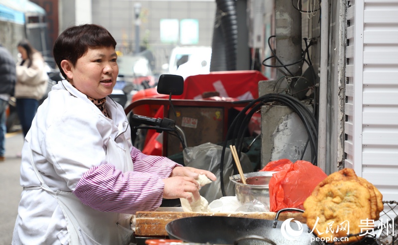 “三八”婦女節當天，在貴陽市南明區一婦女正忙著制作油炸餅。人民網 顧蘭雲攝