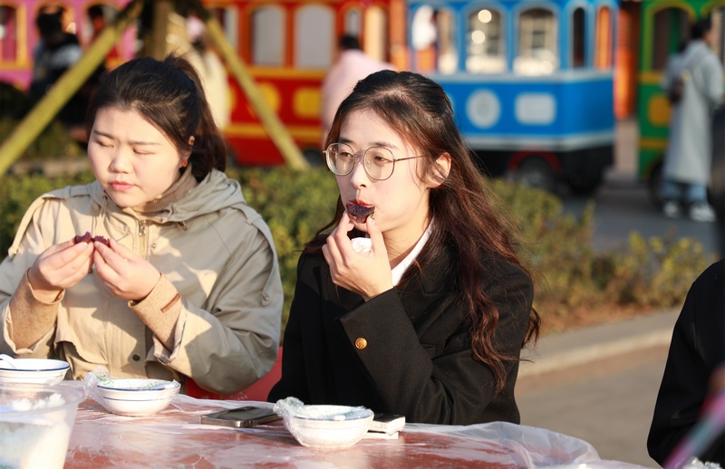 3月8日，两名女性在贵州省大方县首届“爱在工会·缘来是你”单身职工联谊活动长桌宴上品尝美食。周训贵摄