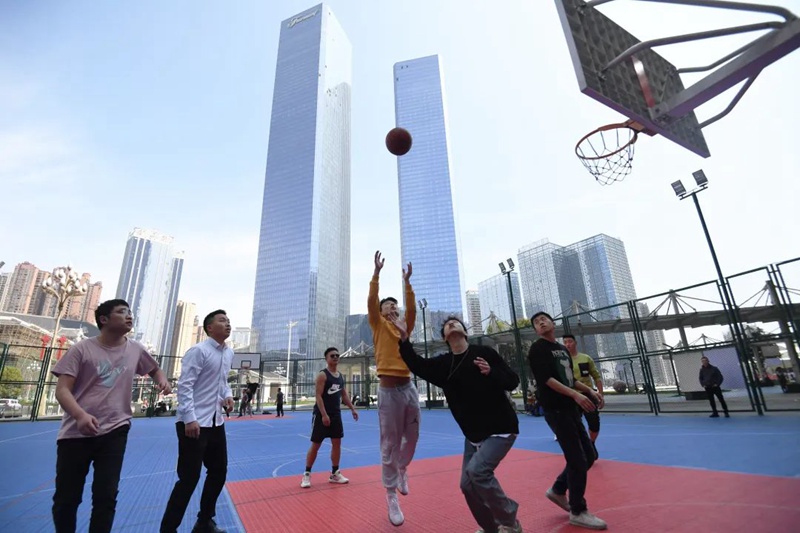 篮球爱好者正在南明区小车河街道兰花广场多功能球场锻炼身体。