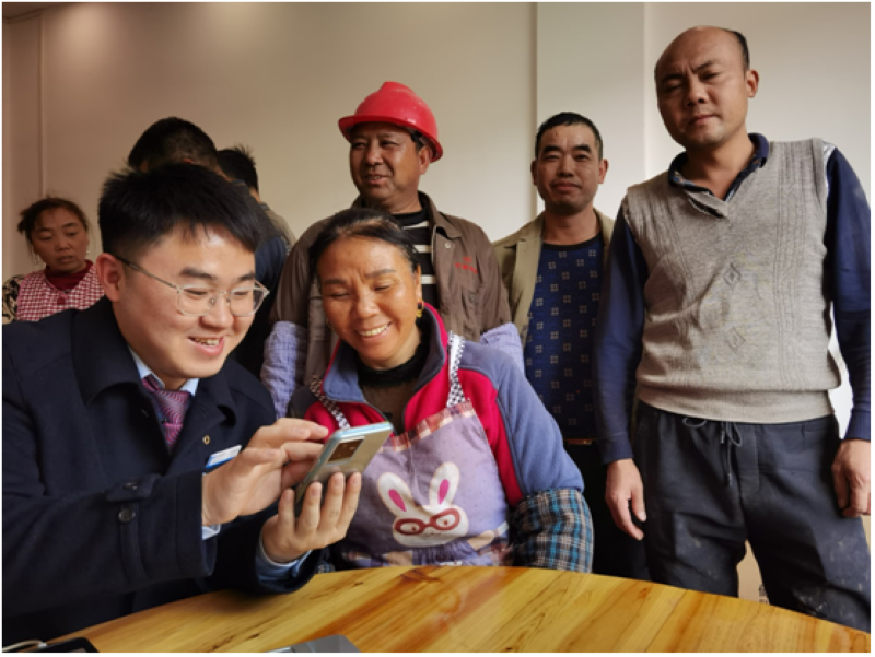 建行黔南龍裡支行青年員工走進貴南高鐵某工地，為農民工開立工資卡。