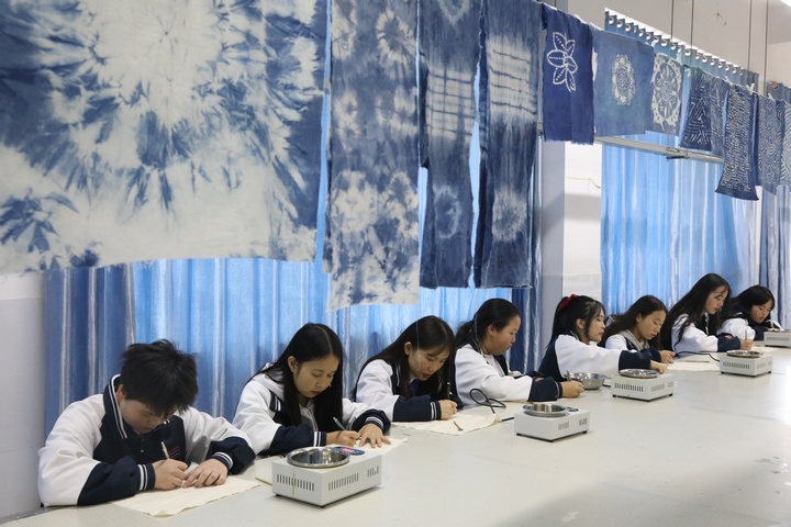 服装专业学生正在进行蜡染图案描绘。