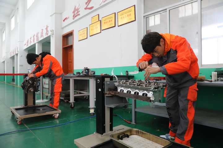 汽车专业学生正在进行发动机拆装。