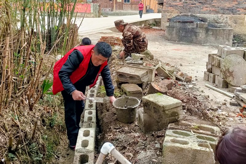 社區干部在幫助居民改造庭院。