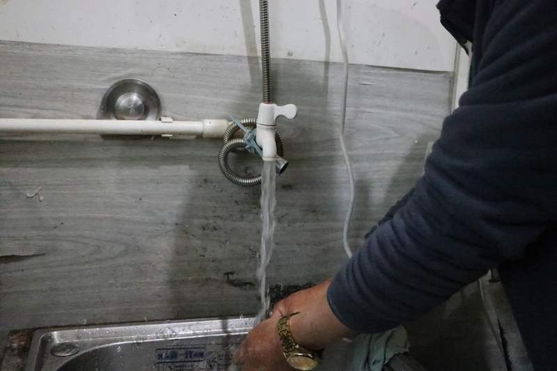 湖南新晃晃州镇洞坡村马溪冲组村民方玉华正在使用自来水。