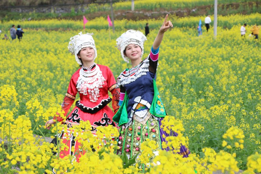 4月1日，苗族自治县洋溪镇蒋家坝油菜花海里，游客展示多姿多彩的民族服饰。