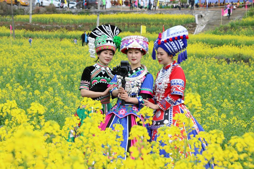 4月1日，印江土家族苗族自治县洋溪镇蒋家坝油菜花海里，游客展示多姿多彩的民族服饰。