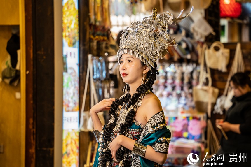 游客穿着新潮的民族服饰在古镇拍照打卡。人民网 阳茜摄