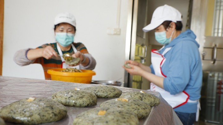 石阡居民李光英和家人在制作清明粑。