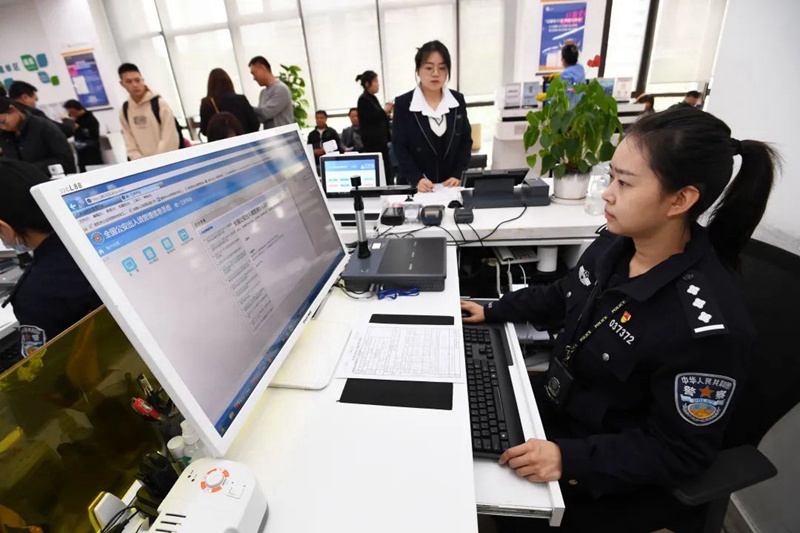 南明区政务服务大厅公安综合窗口的工作人员正通过全国出入境管理信息系统为申请人办理出入境相关证照。