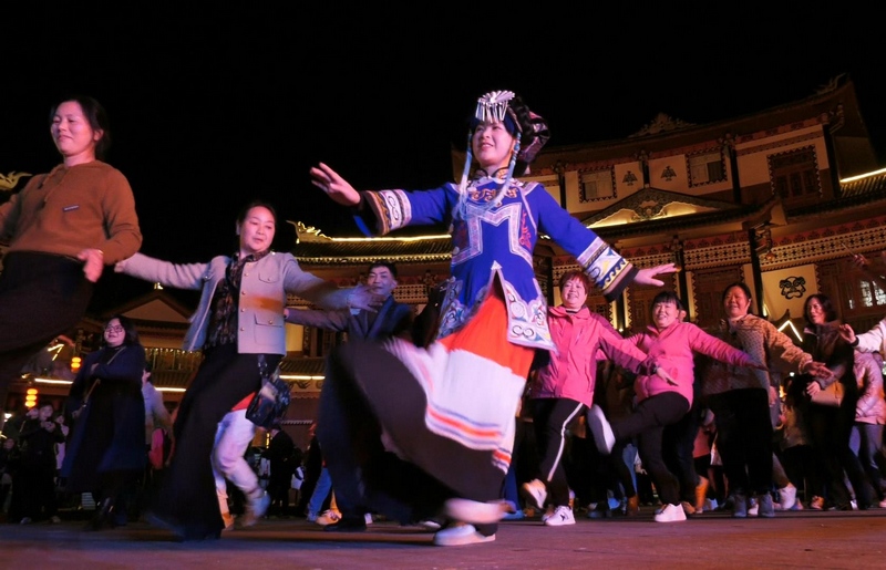 4月8日，大方县奢香古镇篝火晚会上游客学跳彝族舞蹈。何志刚摄