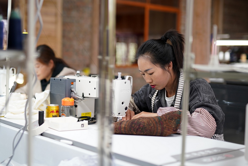 工人在缝制手工绣品。