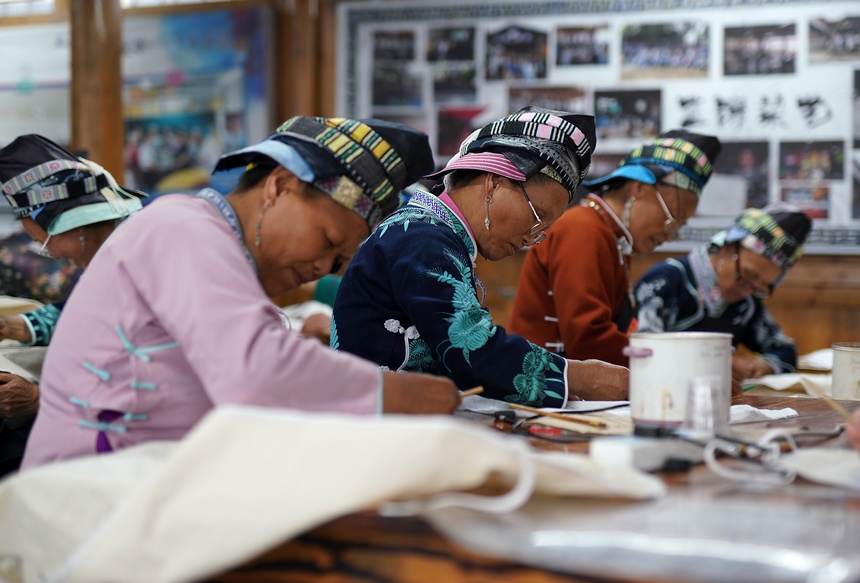 苗族妇女在绘制蜡画。