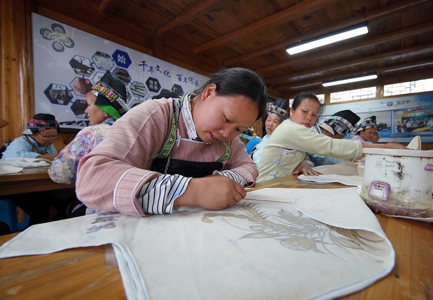 苗族妇女在绘制蜡画。