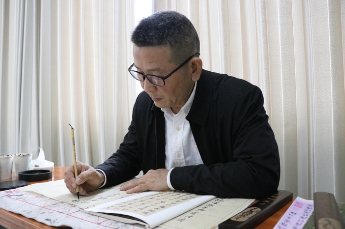 谢谷龄正在练字。