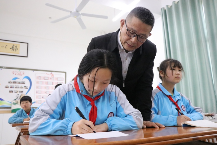 书法课谢谷龄正在查看学生的书写情况。